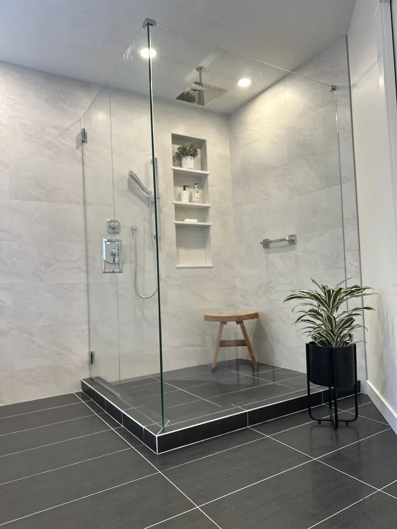 Frameless glass shower with a low profile curb, rain head and niche shelving