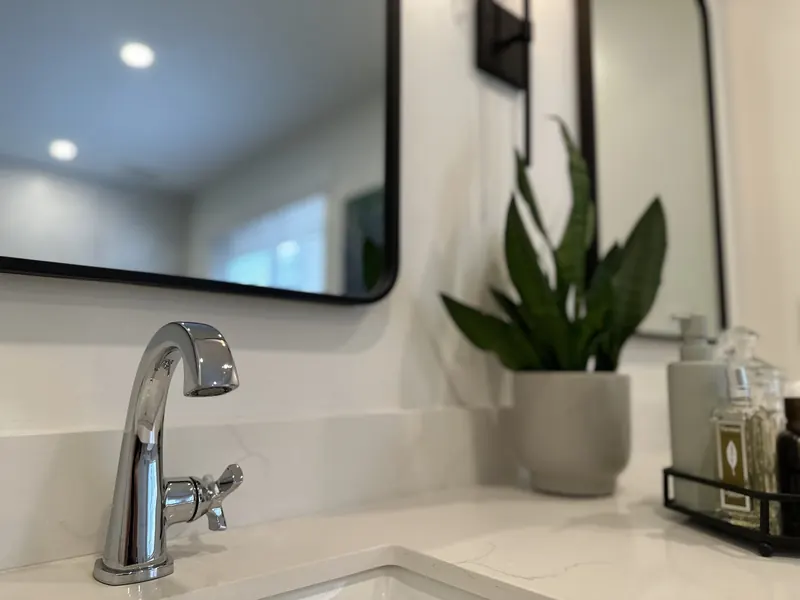 Ensuite vanity with a black framed mirror and chrome faucet
