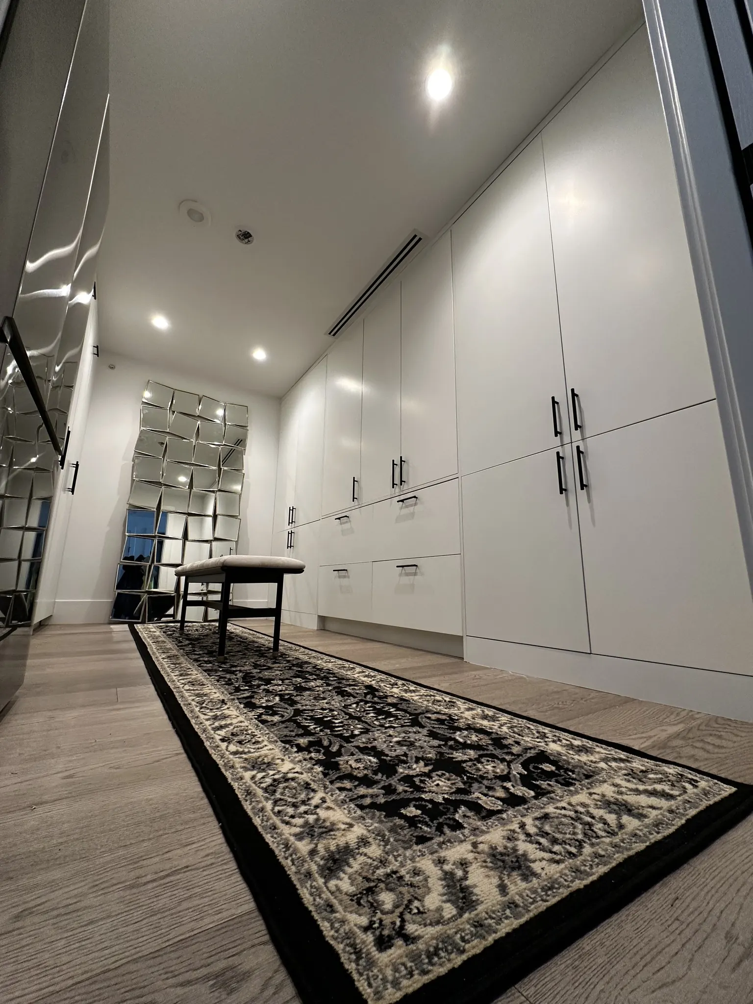 Floor-to-ceiling custom white wardrobes in a White Rock dressing room