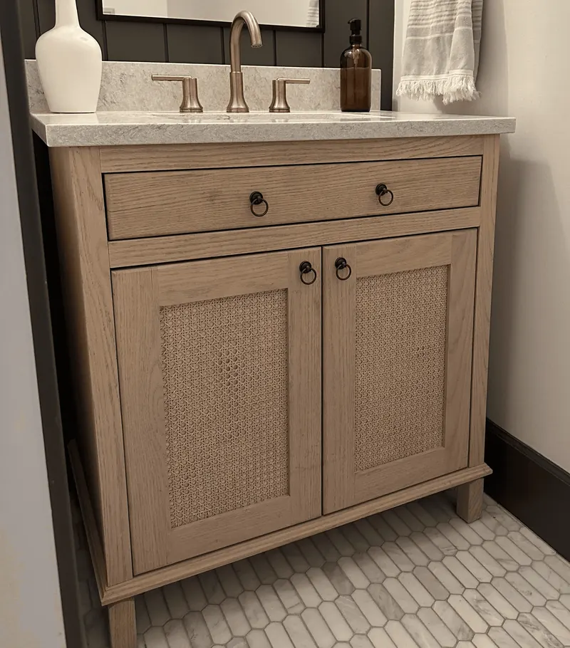 Custom oak vanity cabinet with cane-front doors